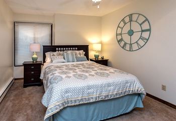 a bedroom with a large bed and a large clock on the wall